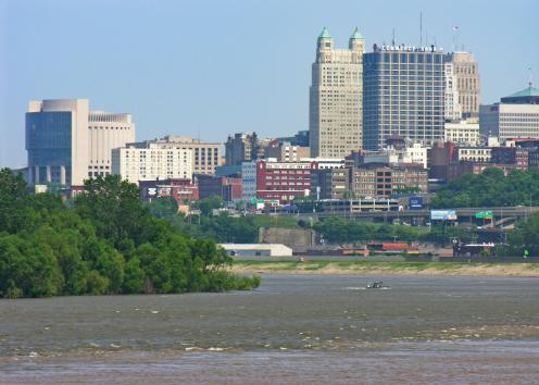 Water color change where rivers meet, city skyline in background