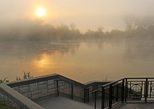 Overlook as sun rises over foggy river