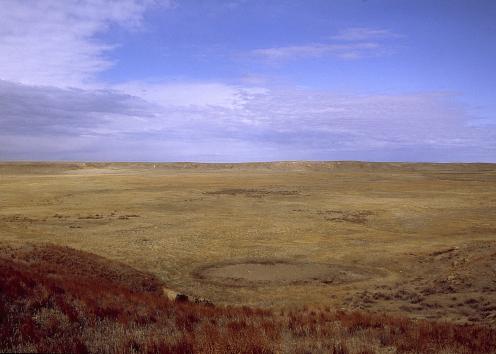 Circular depression about a mile across and 100 feet deep