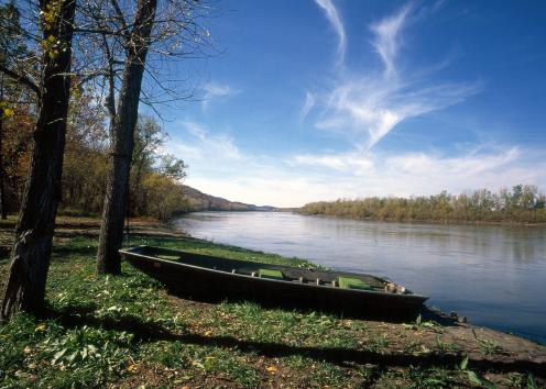 Small boat on bank beside river