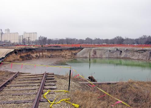 Railroad tracks dead-ending at water-filled sinkhole