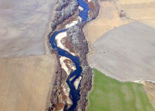 Aerial view of river winding through agricultural fields
